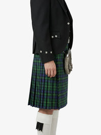 Person wearing a black jacket and green plaid kilt on a white background