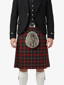 Person wearing a traditional Scottish kilt with a black jacket and white socks on a white background