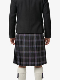 Person wearing a black jacket and plaid kilt on a white background