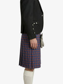 Person wearing a black blazer and red plaid kilt on a white background