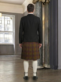 Person wearing a black jacket and plaid kilt in an elegant room with marble columns.