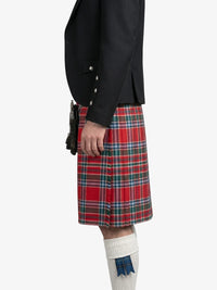 Person wearing a black jacket and red plaid kilt on a white background