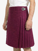 Person wearing a maroon pleated skirt with a belt on a white background