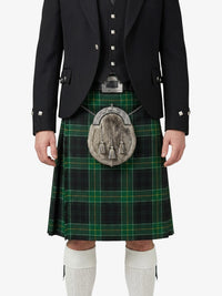 Person wearing a traditional Scottish kilt with a tartan pattern on a white background