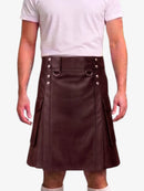 A person wearing a dark brown faux-leather kilt with silver-tone metal hardware, a belt with silver rivets, and side cargo pockets, paired with a light pink t-shirt.