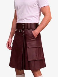 A man wearing a dark burgundy faux-leather kilt with a wide matching belt, silver-tone hardware, and a large cargo pocket on the side, paired with a white t-shirt and white socks against a light gray background.