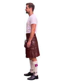 A man shown in profile wearing a dark brown leather kilt, a white t-shirt, white socks with a purple accent, and black shoes, against a plain white background.