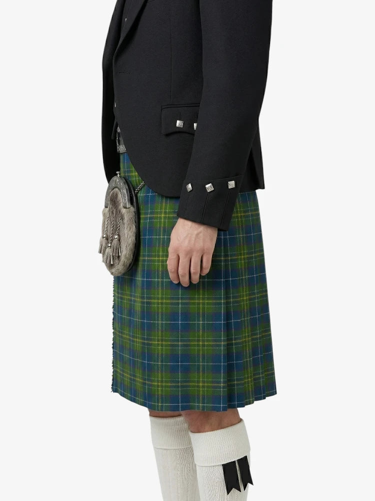 Person wearing a black jacket and green plaid kilt on a white background
