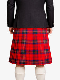 Person wearing a red plaid kilt with a black jacket on a white background
