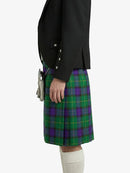 Person wearing a black jacket and green plaid kilt on a white background