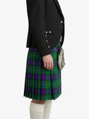 Person wearing a black jacket and green plaid kilt on a white background