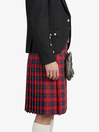 Person wearing a black blazer and red plaid kilt on a white background