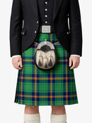 Person wearing a green plaid kilt with a sporran on a white background
