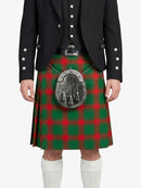 Person wearing a black jacket and red and green plaid kilt on a white background