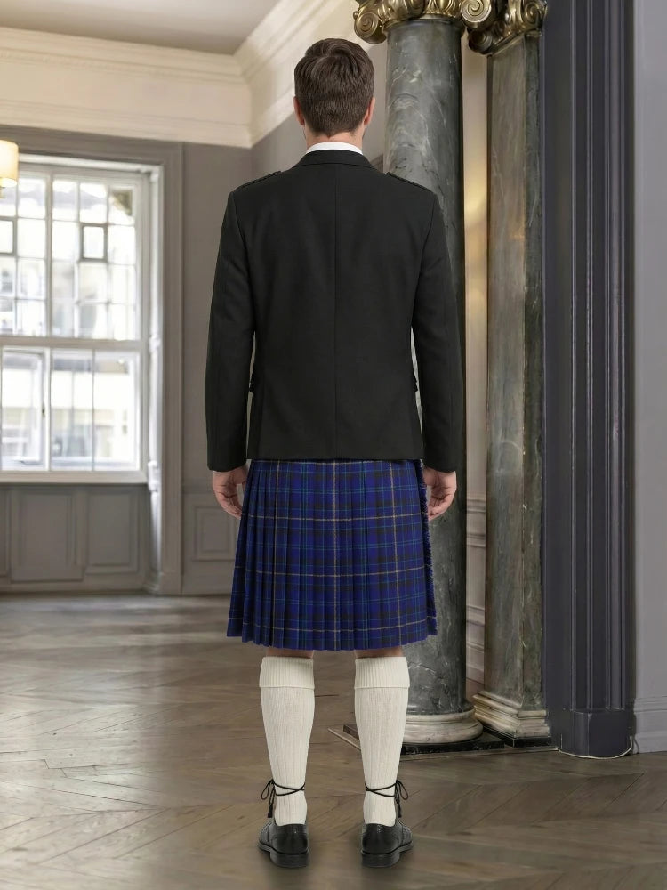Person wearing a dark jacket and blue plaid kilt in an elegant interior setting.