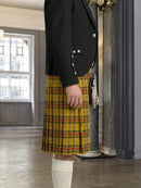 Person wearing a yellow plaid kilt and black jacket in an indoor setting.