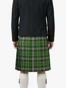 Person wearing a black jacket and green plaid kilt on a white background