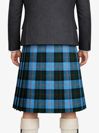 Person wearing a gray blazer and blue plaid kilt on a white background