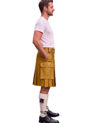A man shown in profile wearing a mustard yellow leather kilt, a light pink t-shirt, white socks, and black shoes, set against a plain white background.