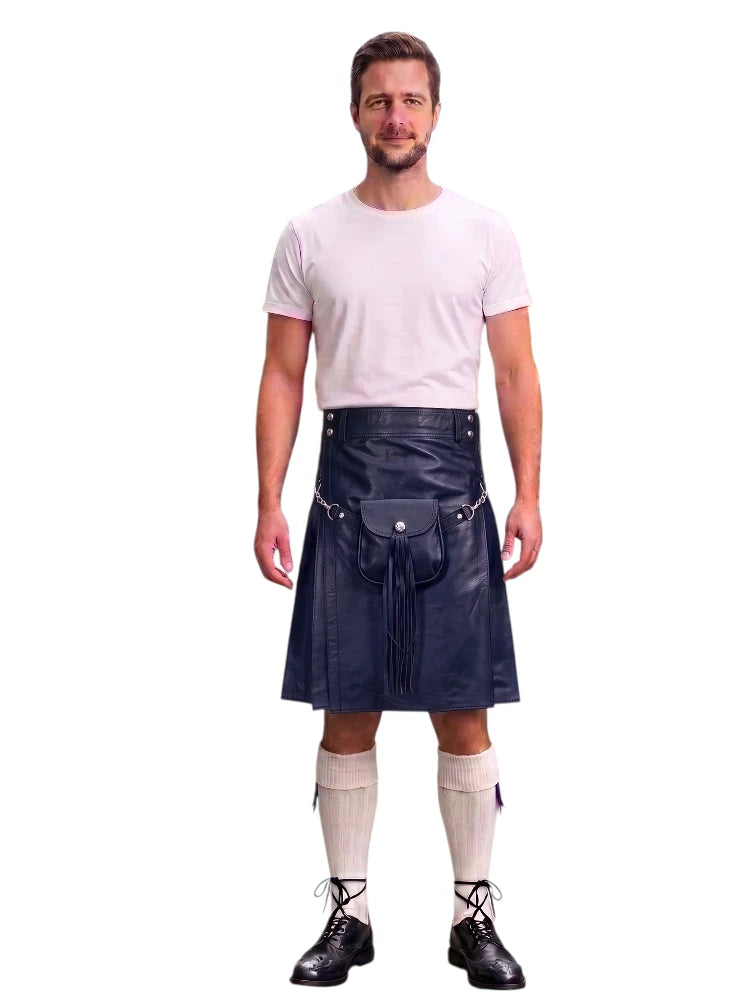 A man modeling a black faux-leather kilt with a matching black waist belt and pouch, paired with a white t-shirt, cream knee-high socks, and black lace-up shoes, against a plain white background.