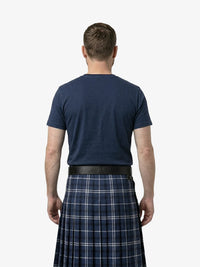 Man wearing a navy t-shirt and plaid kilt on a white background