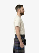 Man wearing a white t-shirt and a plaid kilt on a white background