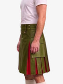 A man wearing a green faux-leather kilt with red pleated side panels, paired with a white t-shirt and white socks, shown from the chest down against a light gray background.