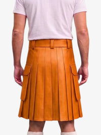 A person shown from the back wearing a mustard-orange pleated leather kilt with side cargo pockets, paired with a light pink t-shirt and white socks, against a plain light gray background.