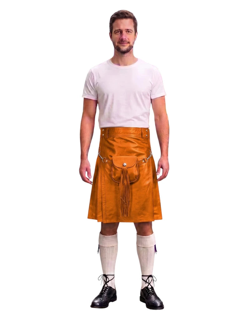 A man modeling a bright orange leather kilt with a front pouch and tassel detail, paired with a white t-shirt, cream knee-high socks, and black lace-up shoes, against a plain white background.
