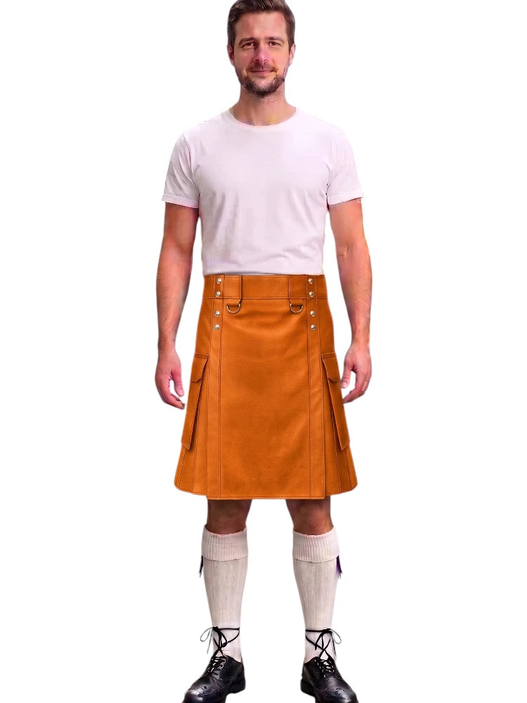 A man modeling a mustard brown leather kilt with silver metal rivets and straps, paired with a white t-shirt, cream knee-high socks, and black lace-up boots, against a plain white background.