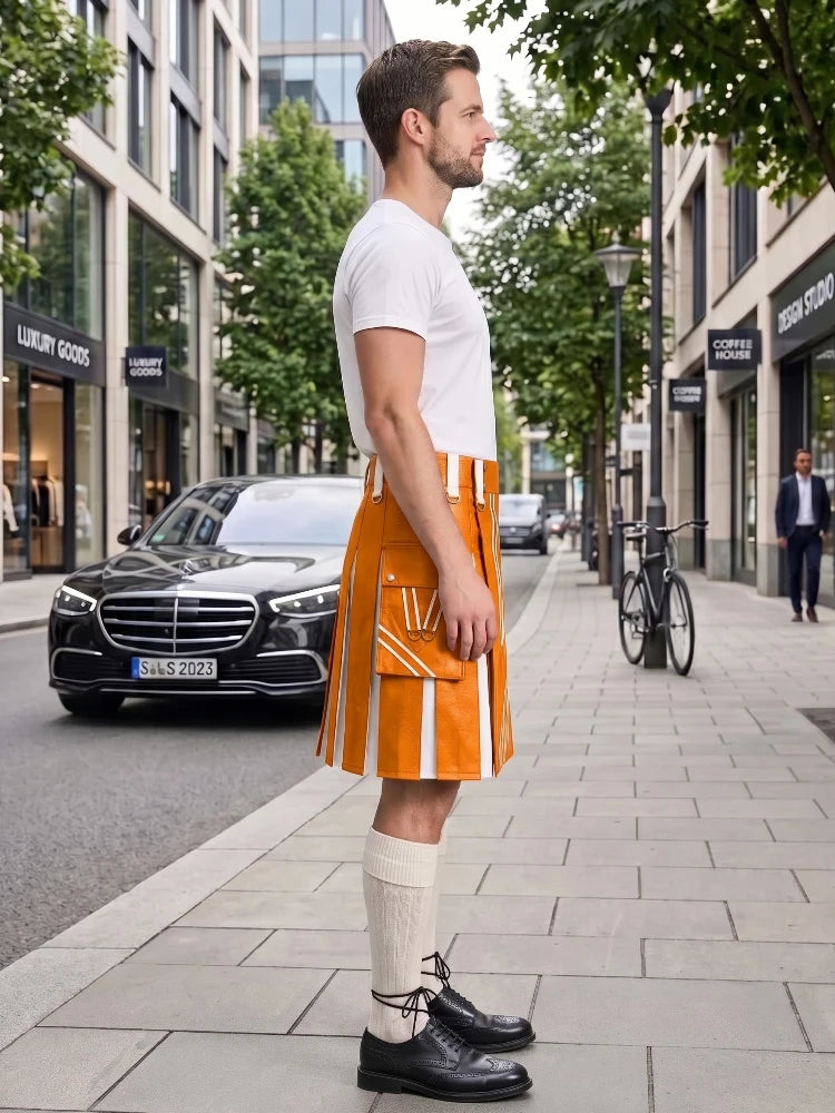 A man stands on a city sidewalk wearing a bright orange kilt with white vertical stripe details, a white t-shirt, cream knee-high socks, and black leather dress shoes. Modern buildings, trees, a parked black Mercedes, and a bicycle are visible in the background.
