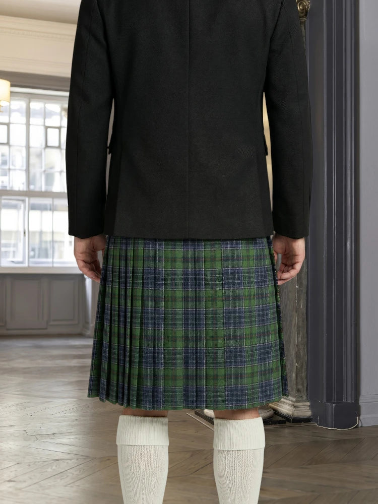 Person wearing a black jacket and green plaid kilt indoors.
