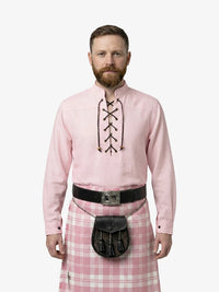 Man wearing a pink shirt with lace-up front and a pink plaid kilt on a white background