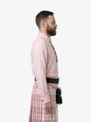 Man wearing a pink shirt and plaid skirt on a white background