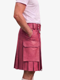 A person wearing a pink pleated leather kilt with a belt and large front flap pocket, paired with a light pink t-shirt, shown from the side against a plain light background.