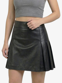 Black leather skirt worn by a person on a white background