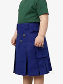 Child wearing a blue pleated skirt with a green top on a white background
