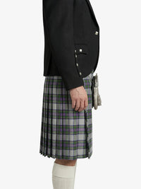 Person wearing a black blazer and plaid kilt on a white background