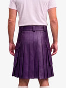 A person shown from the back wearing a purple pleated leather kilt with side cargo pockets, paired with a light pink t-shirt and white socks, against a plain light gray background.