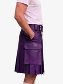 A person wearing a purple leather kilt with a belt, belt buckle, and front flap pocket, paired with a light pink t-shirt, shown from the waist down against a plain white background.