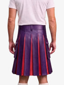 A person shown from the back wearing a purple pleated leather kilt with red vertical stripe accents and side flap pockets, paired with a white t-shirt and white socks, against a light gray studio background.
