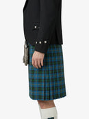 Person wearing a black jacket and blue plaid kilt on a white background