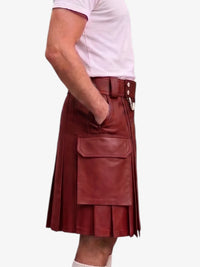 A person wearing a dark red leather kilt with pleated detailing, a belt, and a large front flap pocket, paired with a light pink t-shirt against a plain white background.