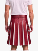 A person shown from the back wearing a pleated red leather kilt with vertical white stripes and silver-tone decorative hardware, paired with a light gray T-shirt against a plain light background.