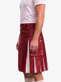 A man wearing a red faux-leather kilt with pleated detailing, a matching belt with a metal ring, and a white t-shirt, shown from the waist down against a light gray background.