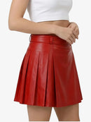 Red pleated skirt worn by a person on a white background