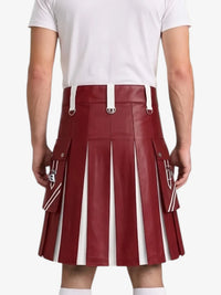 A person shown from the back wearing a pleated red leather kilt with white vertical stripe panels and white belt loops, paired with a white t-shirt and white socks, against a light gray studio background.
