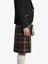Person wearing a black jacket and green plaid kilt on a white background