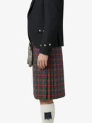 Person wearing a black blazer and red plaid kilt on a white background