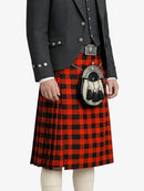 Person wearing a red and black plaid kilt with a dark jacket on a white background